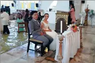  ?? BAUTISTA BANARES TERE / AFP ?? Jobel Delos Angeles, 24, and her groom attend their wedding at a flooded church in Manila on Saturday.