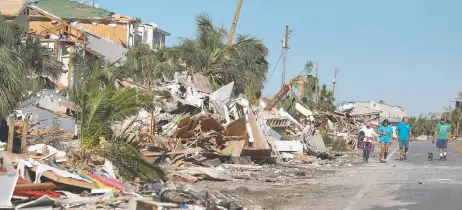  ??  ?? Residentes de Mexico Beach recorren la zona destruida tras el paso de Michael. En la zona, cuatro hospitales y 11 asilos permanecen cerrados.