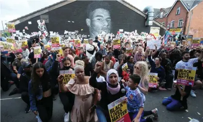  ?? Photograph: Lindsey Parnaby/AFP/Getty ?? Anti-racism protesters in Manchester demonstrat­e in front of a mural of Marcus Rashford after it was defaced in July.