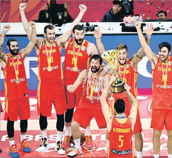  ??  ?? El capitán de la selección española, Rudy Fernández, levanta el trofeo de campeón del mundo ante la euforia de sus compañeros, ayer en Pekín