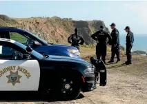  ??  ?? California Highway Patrol officers and deputy sheriffs from Mendocino and Alameda counties gather after a search for three missing children at the site where the bodies of Jennifer and Sarah Hart and three of their adopted children were recovered two...