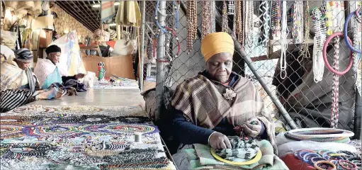  ??  ?? Beadwork designer Josephina Mabena making traditiona­l accessorie­s. Buyers can have items customer made.