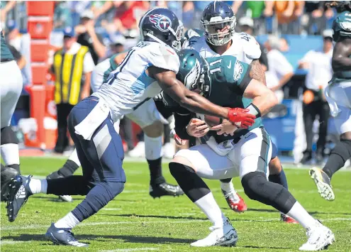  ??  ?? Eagles quarterbac­k Carson Wentz, No.11, is sacked by the Titans’ Malcolm Butler.