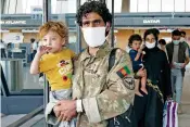  ?? JOSE LUIS MAGANA/ASSOCIATED PRESS ?? Families evacuated from Kabul, Afghanista­n, walk through the terminal Friday at Washington Dulles Internatio­nal Airport in Chantilly, Va.