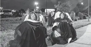  ?? ANDREW WEST/ USA TODAY NETWORK ?? Terri Kado, 66, right, and Patty Tubbs, 68, friends from Fort Myers Beach, Fla., wait in line for a COVID- 19 vaccine in the early morning hours of Dec. 30 at Lakes Park Regional Library. They got in line at midnight. The two enjoyed the experience, watching the moon move through the sky.