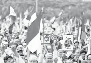  ??  ?? PENUNJUK perasaan membawa sepanduk mengecam Trump dan rejim Israel semasa menyertai demonstras­i di Tugu Negara Monas di Jakarta, semalam. - Gambar Reuters