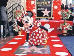  ??  ?? The character of Minnie Mouse poses on her star after it was unveiled on the Hollywood Walk of Fame in Los Angeles, California, US, Jan 22. • (Below) Singer Katy Perry attends the unveiling of the star for Minnie Mouse. • (Right) Model Heidi Klum at...