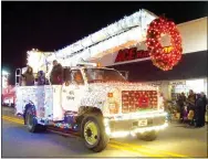  ?? Photo by Randy Moll ?? A city truck carrying city employees and family members was decorated for the season during the annual Gentry Chamber of Commerce Christmas Parade on Saturday.