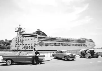  ??  ?? Taxi drivers wait for custumers as cruise ship MSC Opera arrives in Havana. — Reuters photo