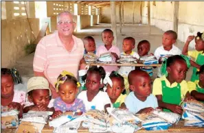  ??  ?? Bella Vistan Ralph Mathey, founder of H.E.A.R. the Cry Foundation, pauses among primary school students in the H.E.A.R. program in the area of Port Salut, Haiti.