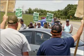  ?? MATT GENTRY — THE ROANOKE TIMES VIA AP ?? Striking UAW members express themselves at vehicles departing the Volvo Trucks North America plant in Dublin, Va., July 18.