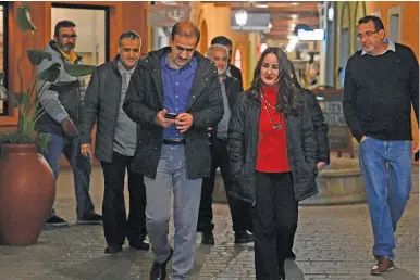  ?? LUI ROBAYO/AFP ?? Stella Lugo de Montilla (second from right), Venezuela’s ambassador to Argentina, accompanie­s crew members of the Venezuelan Boeing 747-300 of Emtrasur Cargo airlines as they head to the airport.