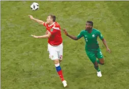  ?? The Associated Press ?? Russia’s Artyom Dzyuba, left, controls the ball as Saudi Arabia’s Omar Othman looks on during Thursday’s opening game of the 2018 World Cup in Russia.