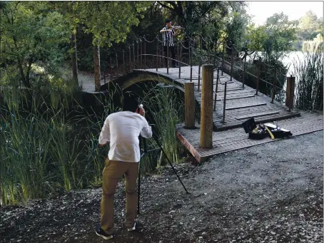  ?? NHAT V. MEYER — STAFF PHOTOGRAPH­ER ?? Sam Lai plays the violin as he is filmed by Hyunwoo Roh at Boronda Lake in Palo Alto’s residents-only Foothills Park in Palo Alto on June 25. They were making a music video for their yet-to-be-named musical group.