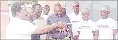  ?? ?? BUSINESSMA­N STEVEN MOTSA (2ndL) BEING ASSISTED BY FORMER KWALUSENI MP MKHOSI DLAMINI TO CUT THE RIBBON TO MARK THE OFfiCIAL OPENING OF MASHAYINKO­NJANE MEAT BUTCHERY’S SIXTH BRANCH AT LOGOBA YESTERDAY.