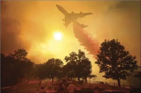  ?? PORTER /THE PRESS DEMOCRAT VIA AP ?? A 747 Global Airtanker makes a drop in front of advancing flames from a wildfire on Thursday, in Lakeport, Calif. KENT