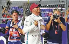  ?? Reuters ?? Mercedes’ Lewis Hamilton celebrates after qualifying in pole position for the Singapore Grand Prix yesterday.