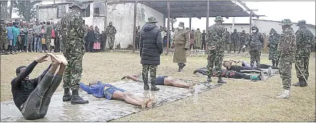  ?? (File pics) ?? Aspiring soldiers doing jack knives while being closely monitored by members of the army recruitmen­t team. (LEFT PIC) A female soldier demonstrat­es to aspiring soldiers how sit-ups are done. Defence force personnel will now be covered for injuries and deaths suffered in the line of duty.