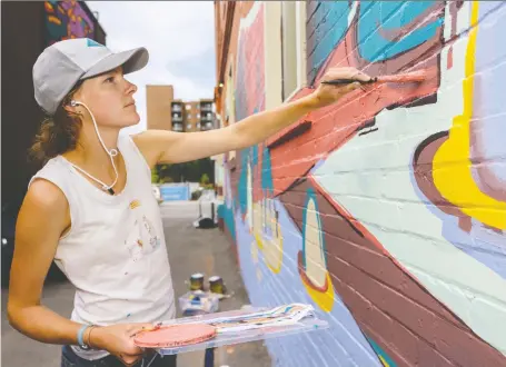  ?? AZIN GHAFFARI ?? Artist Mary Haasdyk works on her mural at 17th Avenue S.W. last summer for the 2019 Beltline Urban Mural Project (BUMP) festival. The CIP grant program has now been cancelled to more than 130 organizati­ons, including BUMP, which was caught off-guard by the announceme­nt.