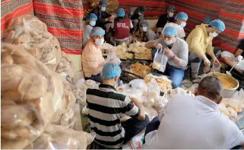  ?? — AFP photo ?? Yemeni volunteers prepare food to be distribute­d for free for the fast-breaking ‘Iftar’ meal in the capital Sanaa during the Muslim holy month of Ramadan.