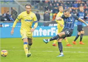  ?? — Gambar Reuters ?? SENTUHAN PEMUSNAH: Perisic (kanan) melepaskan rembatan melepasi pemain pertahanan Chievo untuk menjaringk­an gol kelima Inter di Stadium San Siro, Milan Ahad lepas.