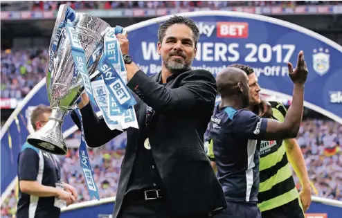  ??  ?? Jubel nach dem Aufstieg: Huddersfie­ld-Trainer David Wagner mit der Trophäe der zweiten Liga, der Championsh­ip.