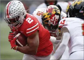  ?? JAY LAPRETE - THE ASSOCIATED PRESS ?? Ohio State running back J.K. Dobbins, left, breaks through the line of scrimmage to score a touchdown against Maryland during the first half of an NCAA college football game Saturday, Nov. 9, 2019, in Columbus, Ohio.