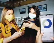  ?? RIANA SETIAWAN/JAWA POS ?? PROGRAMMIN­G: Michelle A. Dinata dan Tinara N. Wiryonoput­ro memamerkan prototipe aplikasi Monete.