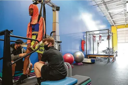  ?? Photos by Jon Shapley / Staff photograph­er ?? Jordyn Hawkins, 16, grimaces with determinat­ion on a treadmill with help from DeAndre Sumrall, left, and Nate Smeester.