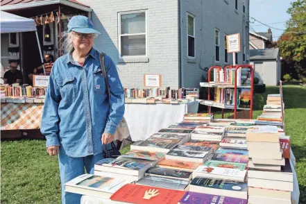  ?? PHOTOS BY NICOLAS GALINDO/THE COLUMBUS DISPATCH ?? Tina Willis peruses books at Bookspace outside of the owner Charlie Pugsley's apartment in Columbus. His twice monthly front-yard sales (when the weather is nice) have been so successful, he's been able to focus full time on the endeavor.