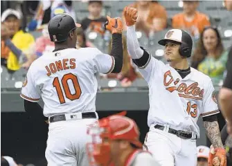  ?? GAIL BURTON/ASSOCIATED PRESS ?? Orioles center fielder Adam Jones, left, is congratula­ted by Manny Machado after hitting a solo home run against the Phillies in the first inning. It produced the only run for the Orioles, who struck out 13 times.