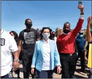  ??  ?? Gov. Gretchen Whitmer (center) joins others June 4 during a rally in Highland Park, Mich., in honor of George Floyd, a Black man who died the previous week while being arrested by Minneapoli­s police. Stories circulatin­g online have incorrectl­y asserted that Whitmer, the Democratic governor of Michigan, is the niece of billionair­e investor and philanthro­pist George Soros. A look at the lineages of Whitmer and Soros shows he is not her uncle. (Clarence Tabb, Jr./Detroit News via AP)