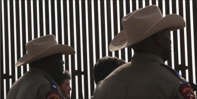  ?? AP FILE ?? AT THE BORDER: Texas Department of Safety troopers are silhouette­d against the Texas Border Wall on Dec. 18 in Rio Grande City, Texas.