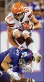  ?? ELSA / GETTY IMAGES ?? Cleveland Browns tight end Devon Cajuste tries to leap over Giants defender Calvin Munson last month in a preseason game in New Jersey. Cajuste was not among the four tight ends the team kept Saturday.
