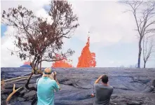  ?? JAE C. HONG/ASSOCIATED PRESS ?? Heath Dalton, right, and Jim Carpenter take pictures as fissures spew lava in the Leilani Estates subdivisio­n near Pahoa, Hawaii, on Tuesday.