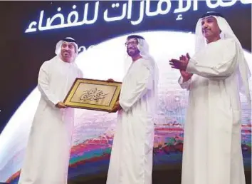  ?? Ahmed Kutty/Gulf News ?? Dr Khalifa Mohammad Thani Al Rumaithi (centre), former chairman of the UAE Space Agency, recieves a memento from Dr Ahmad Belhoul Al Falasi (left), Minister of State for Higher Education and Chairman of the UAE Space Agency, and Dr Mohammad Al Ahbabi,...