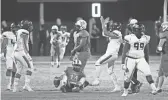  ?? ROB SCHUMACHER/THE REPUBLIC ?? Desert Edge defensive end Cameron Steele (15) celebrates the sack of Sunrise Mountain quarterbac­k Travis Ward (14) during a game in Peoria.