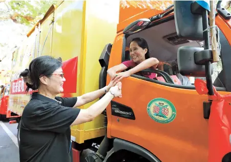  ??  ?? A former resident of Kangding Road is seen leaving her old home in a moving truck yesterday. She is among the 600 families who are moving out of a dilapidate­d, decades-old shikumen neighborho­od on the street. — Jiang Xiaowei