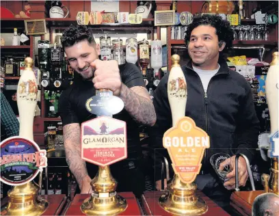  ??  ?? Nathan Cleverly and Colin Charvis pull and drink a pint at the Brynffynon pub