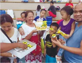  ?? SUNSTAR FOTO / ALLAN CUIZON ?? PLENTY TO SMILE ABOUT. Leonarda Pañares, seen here with her children and grandchild­ren, celebrates her 60th birthday at the Enan Chiong Activity Center.
