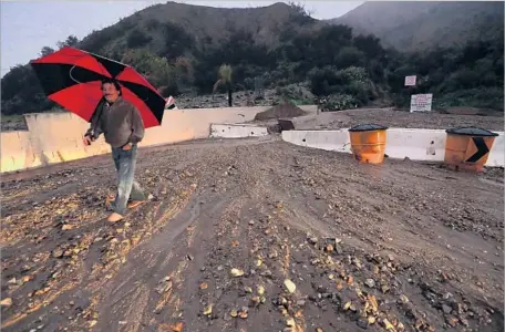  ?? Genaro Molina Los Angeles Times ?? JERRY KATZ walks along a mud flow at Mel Canyon and Brookridge roads in the area of Duarte burned in last June’s Fish fire. City officials called for a mandatory evacuation in the neighborho­od, but Katz and others stayed. He blamed the orders to leave on nervous lawyers.