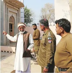  ?? Reuters ?? A villager speaks with police officers a mob lynched a man in Tulamba Village, in Mian Channu.