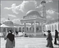  ?? New York Times file photo ?? Visitors walk through Aleppo’s Umayyad mosque courtyard (left photo) in 2007 before Syria’s civil war. The mosque’s 150-foot minaret, in place since 1090, rises over the complex. At right, in a photo take March 10, the minaret is gone and rubble covers...