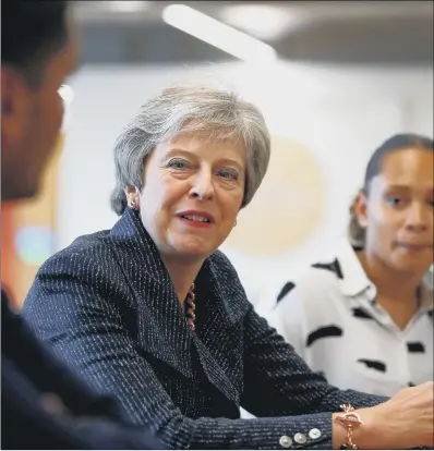  ??  ?? Theresa May talks to employees at WPP who have come through micro fellowship­s and apprentice­ships, after a meeting with business leaders whose companies are inaugural signatorie­s of the Race at Work Charter, at the Southbank Centre in London.