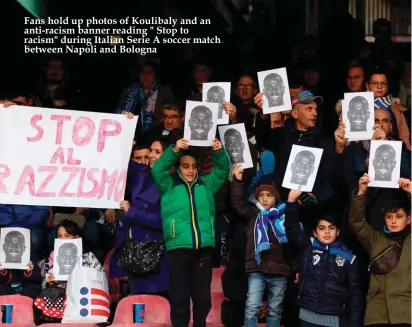  ??  ?? Fans hold up photos of Koulibaly and an anti-racism banner reading " Stop to racism" during Italian Serie A soccer match between Napoli and Bologna