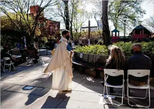  ?? BEN GRAY FOR THE AJC ?? Rector Simon Mainwaring prepares to lead the Maundy Thursday service at All Saints’ Episcopal Church in Atlanta as part of the lead-up to Easter. The church is planning at least eight services today, all outdoors, with worshipper­s following COVID-19 safety protocols.