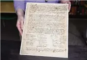  ?? Jessica Hill / Associated Press ?? Connecticu­t Historical Society Collection­s Associate Julia Morrow displays an original complaint letter dated back to 1669 against Katherine Harrison, Tuesday in Hartford. Harrison, of Wethersfie­ld was tried multiple times for witchcraft.