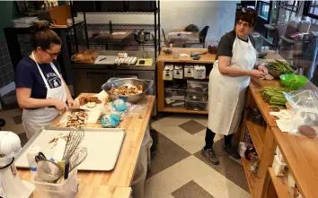  ?? ?? Erika Bruce, left, and Beth Taylor, chat while they cut vegetables for quiche in the former Spork Pit BBQ space in Garfield.