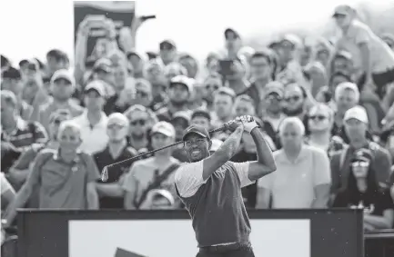  ?? THE ASSOCIATED PRESS ?? Tiger Woods hits off the 18th tee during the third round of the British Open on Saturday in Carnoustie, Scotland. Woods shot a 66 and is four shots behind the leaders heading into today’s final round.