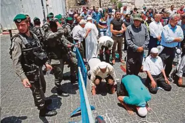  ??  ?? MUSLIM Palestin yang enggan memasuki pekarangan Masjid Al-Aqsa buat hari kedua semalam menunaikan solat di luar di pintu masuk utama ke pekarangan itu di Kota Lama Baitulmaqd­is. - AFP